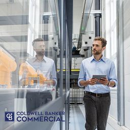 Man in warehouse Looking at Robot